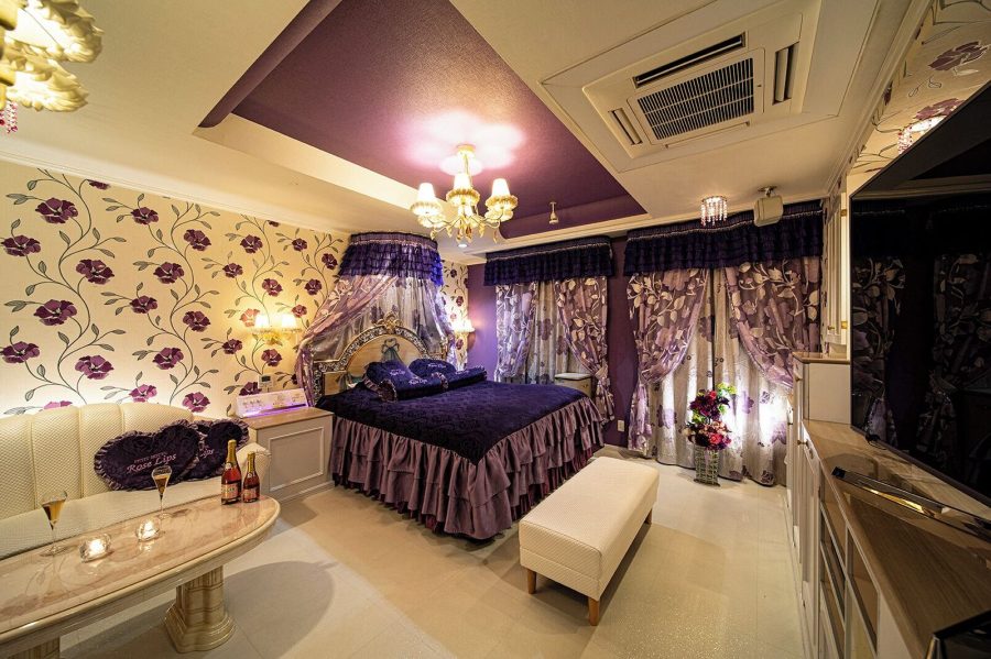 Bedroom at Hotel Rose Lips Shinsaibashi with floral wallpaper, a chandelier and a canopy over the bed