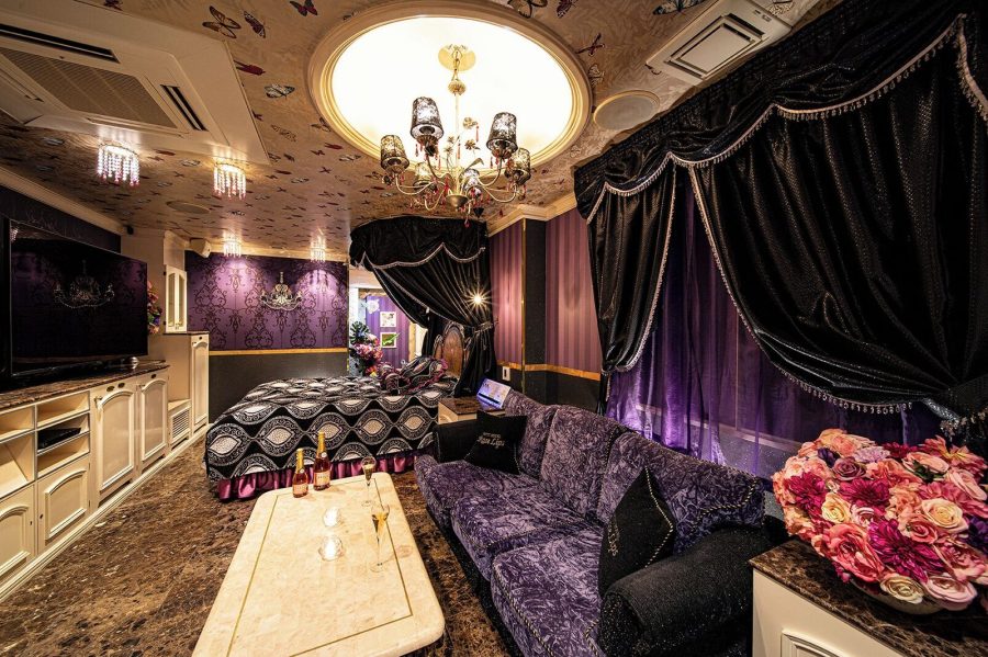 Purple baroque suite at Hotel Rose Lips Shinsaibashi with a chandelier, velvet sofa and a large wall-mounted TV