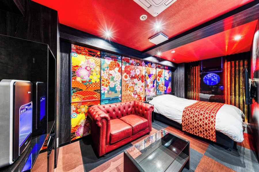 Room at Hotel Lotus Umeda with a red leather sofa, a red ceiling and colourful Japanese-pattern wall panels